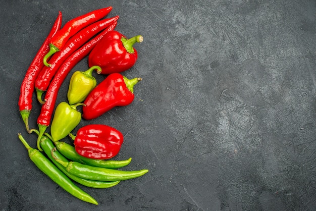 Bovenaanzicht symmetrische ingelijste paprika's met zijn heldere kleuren op een donkere ondergrond met vrije ruimte