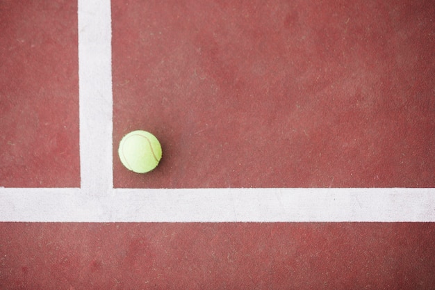 Bovenaanzicht tennisbal op hoek op veld