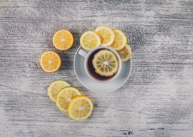 Bovenaanzicht thee met plakjes citroen op grijze houten achtergrond. horizontaal