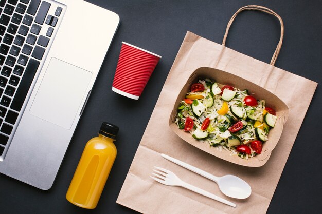 Bovenaanzicht toetsenbord en salade op zwarte achtergrond