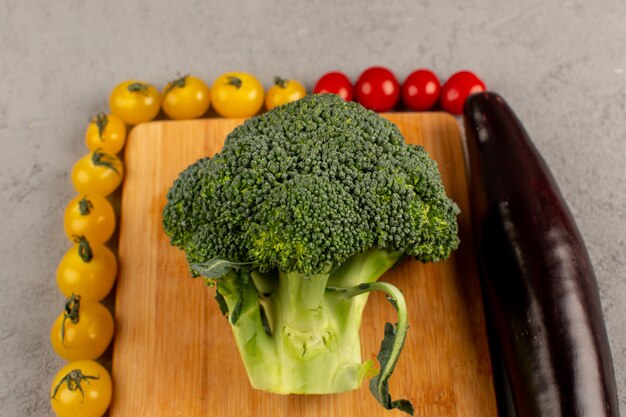 bovenaanzicht tomaten broccoli aubergine vers rijp bekleed op de grijze vloer