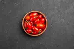 Gratis foto bovenaanzicht tomaten in kom rijpe rode tomaten in kom in het midden van de donkere tafel