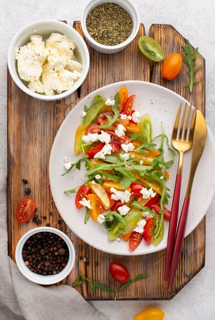 Bovenaanzicht tomatenmix salade met fetakaas, rucola en zwarte peper