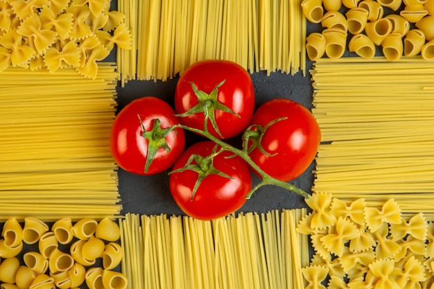 Bovenaanzicht tros tomaten met pasta en spaghetti in de vorm van een decor