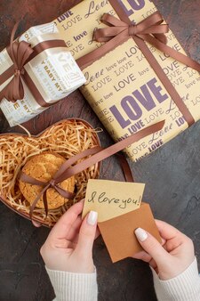 Bovenaanzicht valentijnsdag cadeautjes met ring en koekjes op donkerbruine achtergrond liefde kleuren cadeau gevoel huwelijk vakantie paar