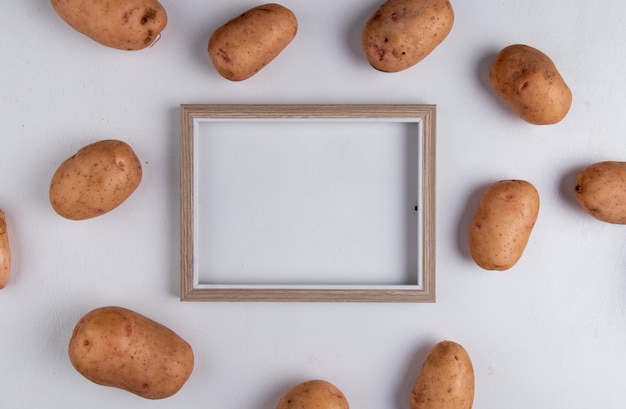 Bovenaanzicht van aardappelen rond frame op paars met kopie ruimte