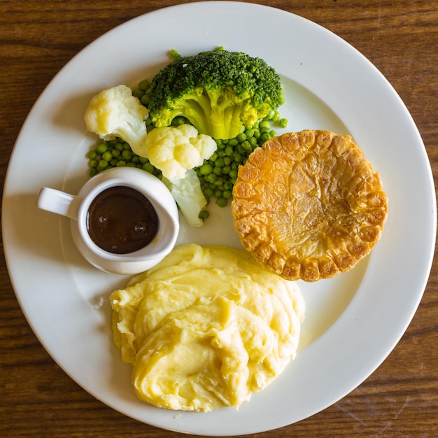 Bovenaanzicht van aardappelpuree, broccoli en bloemkool met bruine saus