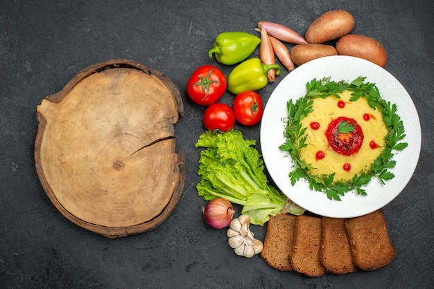 Gratis foto bovenaanzicht van aardappelpuree met donkere broden en groenten op donker