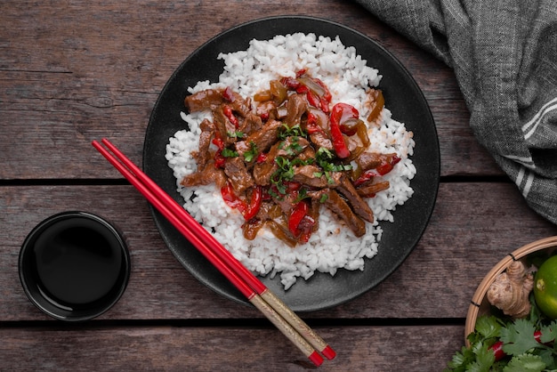 Bovenaanzicht van Aziatische rijstgerecht met vlees en eetstokjes