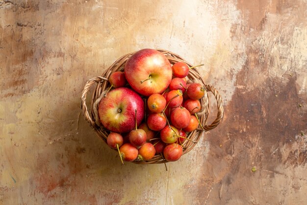 Bovenaanzicht van bessen houten mandje met bessen appels op de roomtafel