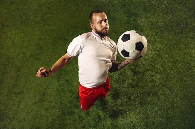 Bovenaanzicht van blanke voetbal of voetballer op groen