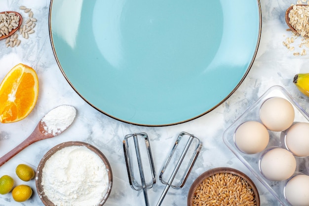 Bovenaanzicht van blauwe lege plaat en ingrediënten voor de gezonde voeding op marmeren oppervlak
