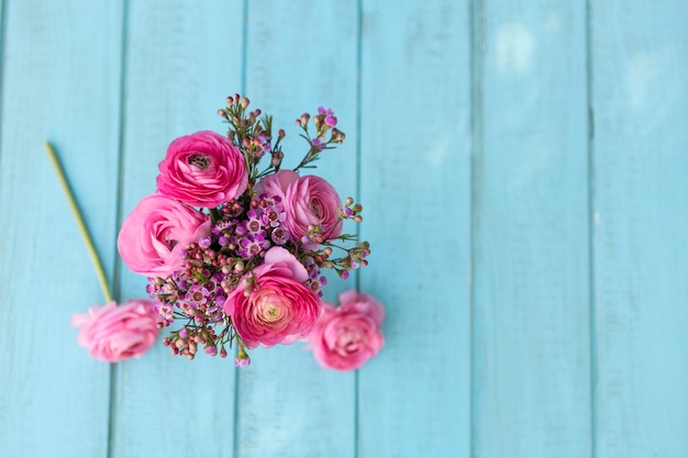 Bovenaanzicht van bloemen in roze tinten op blauwe ondergrond