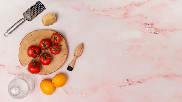 Bovenaanzicht van boerderij verse rode tomaten en citroen met keukenbestek