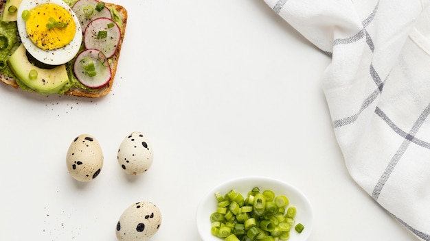 Bovenaanzicht van broodje ei en avocado met tafellaken