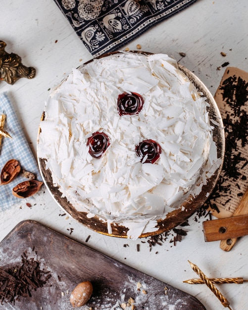 Bovenaanzicht van cake versierd met witte chocoladestukjes op tafel