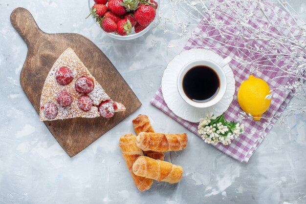 Bovenaanzicht van cakeplak met verse rode aardbeien zoete armbanden en koffie op licht bureau, zoet bak koekjes koekjes thee gebak