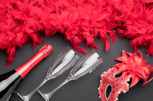 Gratis foto bovenaanzicht van carnaval maskers met veren en champagnefles