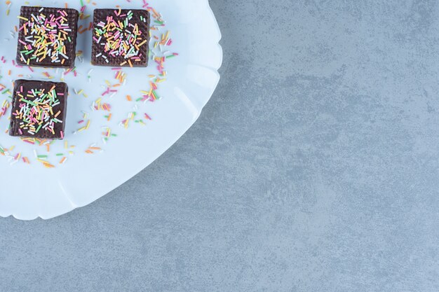 Bovenaanzicht van chocoladewafels op witte plaat. op de hoek van de foto.