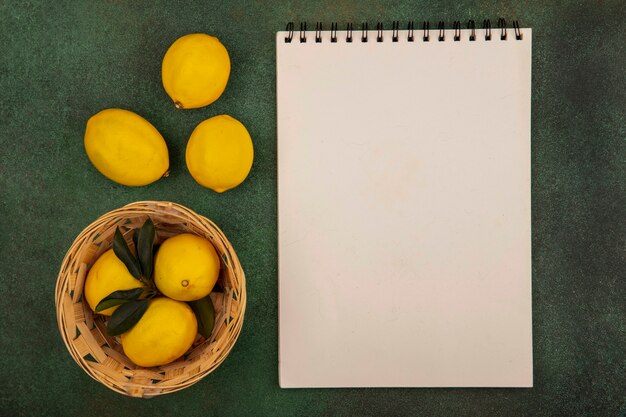 Bovenaanzicht van citrusvruchten citroenen op een emmer met citroenen geïsoleerd op een groen oppervlak met kopie ruimte