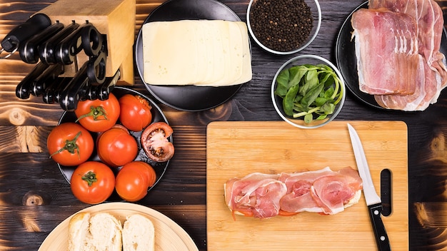 Bovenaanzicht van de bereiding van het sandwichproces op houten tafel