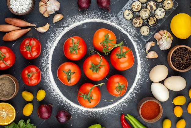 Gratis foto bovenaanzicht van de voorbereiding van het diner met verse groenten, eieren, meel, citroen, kumquats, kruiden op zwarte achtergrond