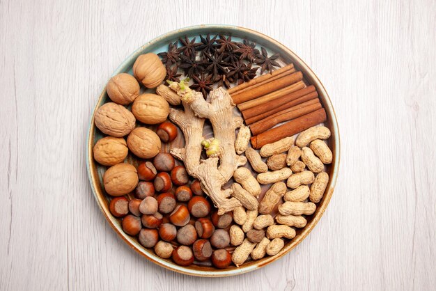 Bovenaanzicht van dichtbij noten bord walnoten hazelnoten kaneelstokjes pinda's en steranijs