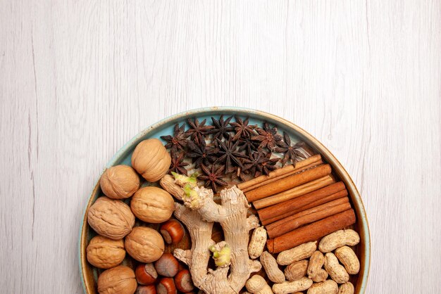Bovenaanzicht van dichtbij noten hazelnoten walnoten pinda's kaneel en steranijs op tafel