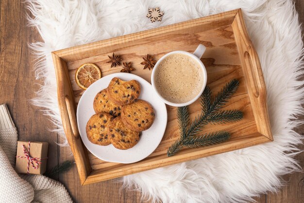 Bovenaanzicht van dienblad met plaat van koekjes en kop warme chocolademelk