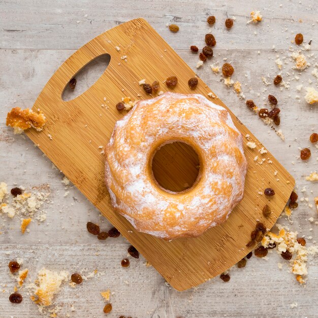 Bovenaanzicht van donut op snijplank met rozijnen