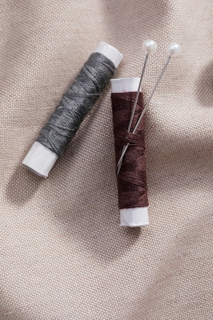 Bovenaanzicht van draadspoelen met naalden op textiel