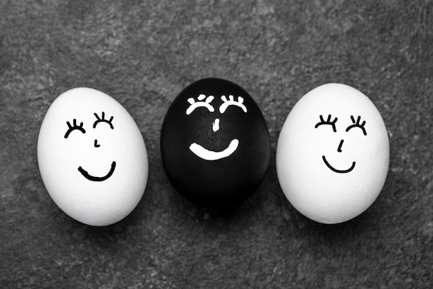 Bovenaanzicht van drie verschillende gekleurde eieren met gezichten voor zwarte levens zijn belangrijk voor beweging