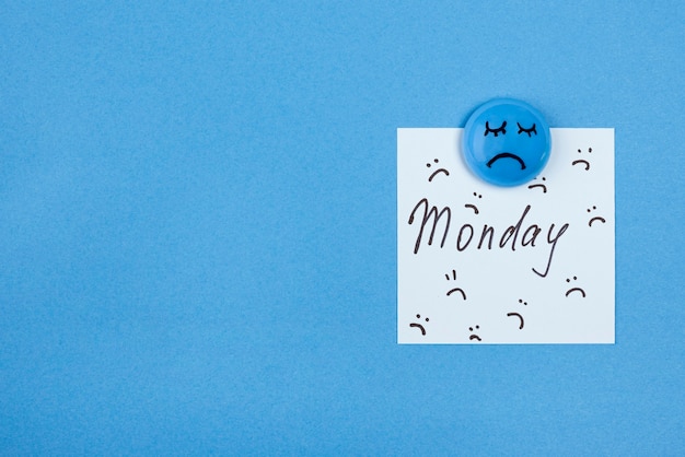 Bovenaanzicht van droevig gezicht met notitie en kopieer ruimte voor blauwe maandag