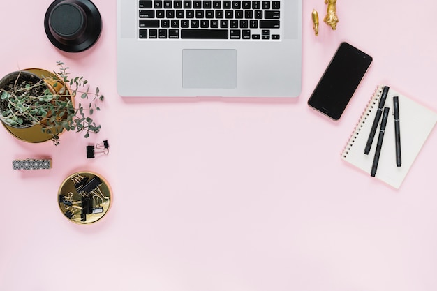 Bovenaanzicht van een bureau met een laptop en mobiele telefoon