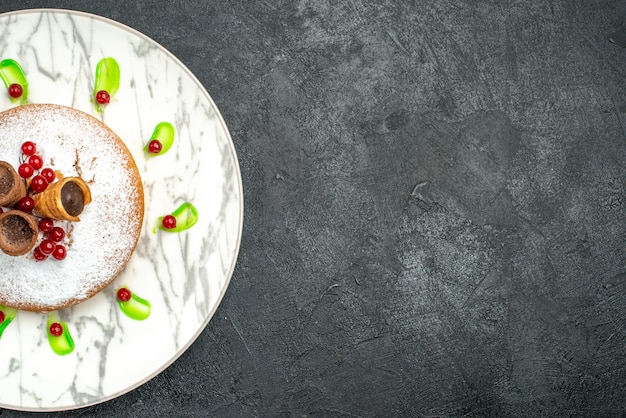 Bovenaanzicht van een close-up een cake grijze plaat van een cake met bessen groene saus wafels