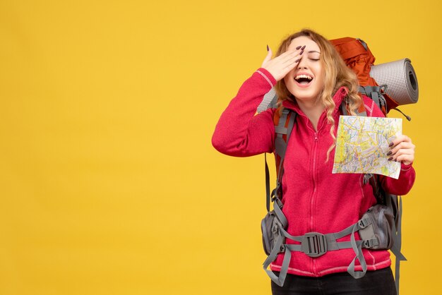 Bovenaanzicht van een jong tevreden reizend meisje in medisch masker houden en kaart tonen genieten van haar succes