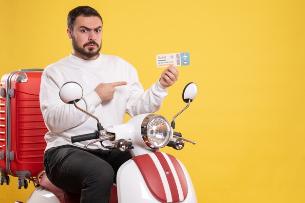 Bovenaanzicht van een jonge onzekere emotionele reizende man die op een motorfiets zit met een koffer erop met een kaartje op geel