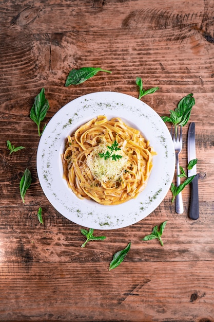 Bovenaanzicht van een kaasachtige pasta op een witte plaat