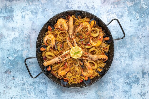 Bovenaanzicht van een pan met smakelijke zeevruchten en pastagerecht