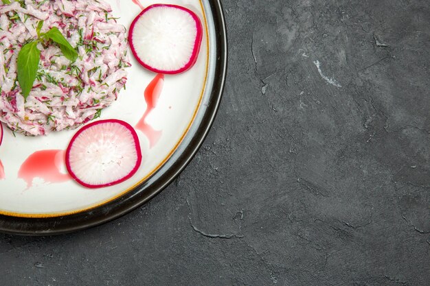 Bovenaanzicht van een smakelijk gerecht radijskruiden en rode saus op het bord