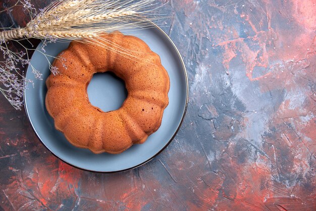 Bovenaanzicht van een taartblauw bord met taarttarweoren en boomtakken