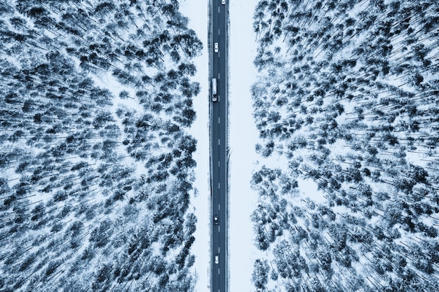 Bovenaanzicht van een weg omringd door sneeuw en sparren