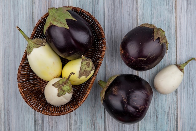 Bovenaanzicht van egglants in mand en op houten achtergrond