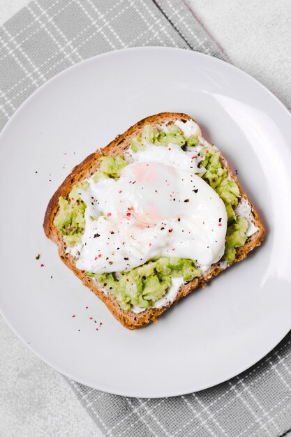 Bovenaanzicht van ei met avocado toast op plaat