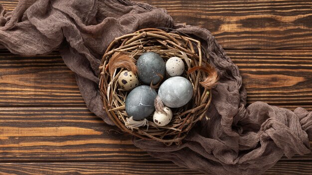 Bovenaanzicht van eieren voor Pasen met stof en vogelnest