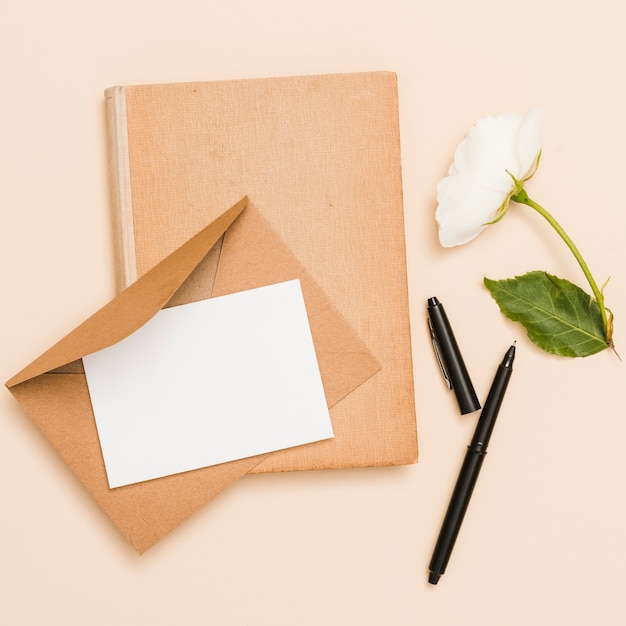 Bovenaanzicht van envelop, bloem en boek