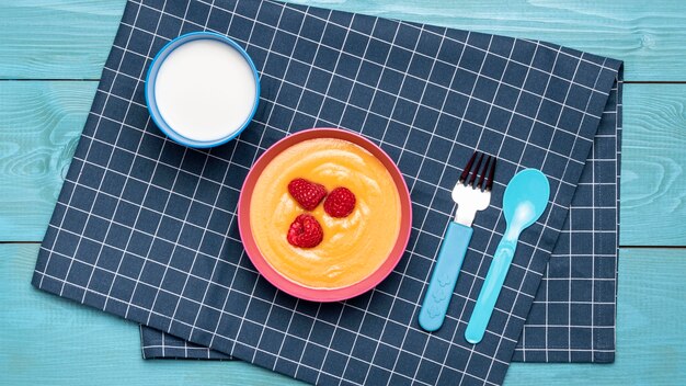 Bovenaanzicht van frambozen met babyvoeding in kom