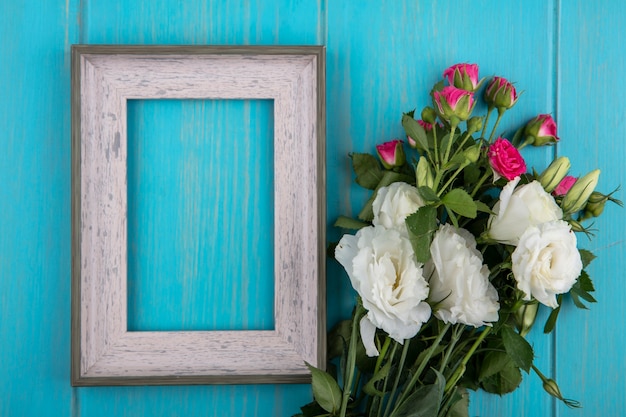 Bovenaanzicht van frame en bloemen op blauwe achtergrond met kopie ruimte