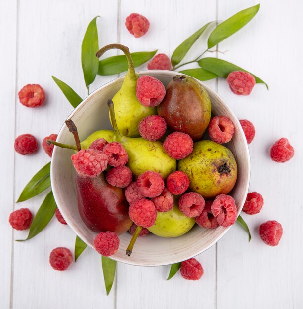 Bovenaanzicht van fruit ain kom met bladeren op houten oppervlak