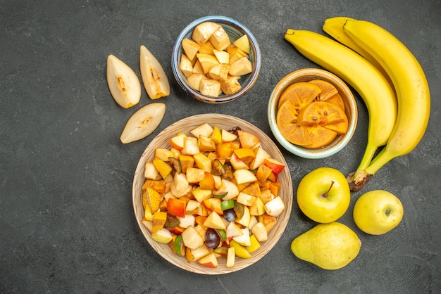 Bovenaanzicht van fruitige salade met vers gesneden fruit op de donkergrijze achtergrond